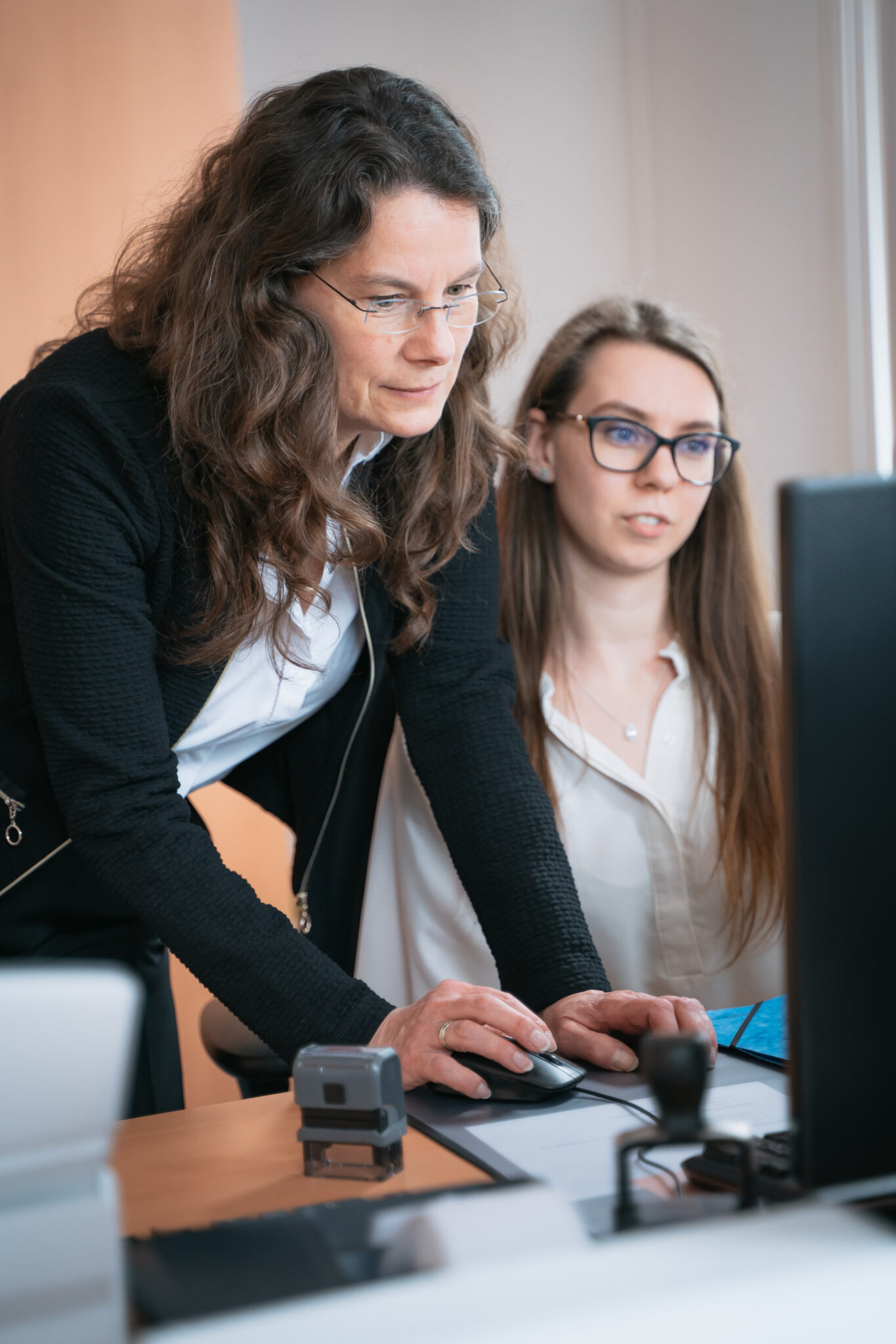zwei Frauen am PC, die eine zeigt der anderen etwas am PC
